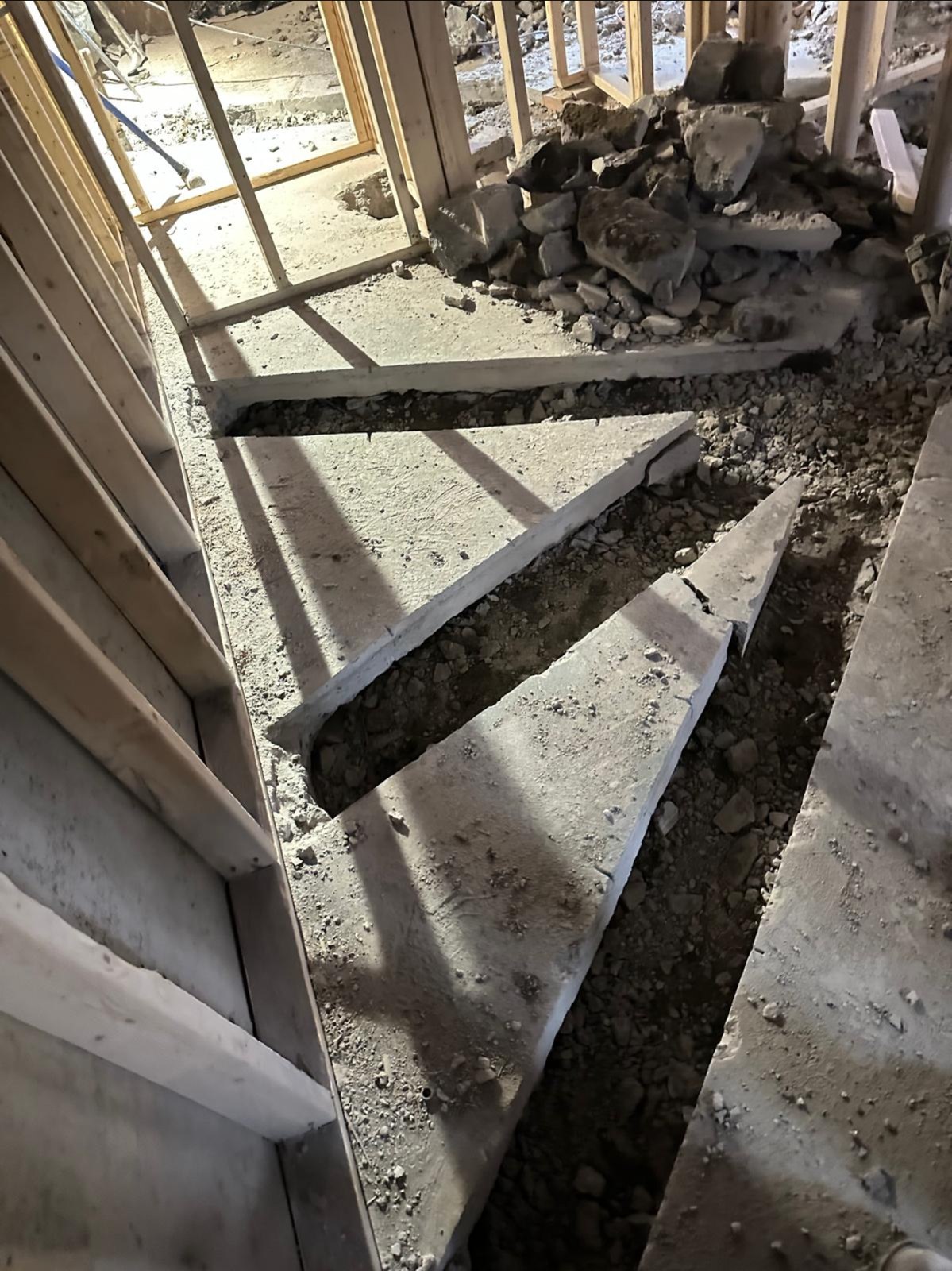Dalle de béton ouverte en tranchées pour préparer une intervention de plomberie